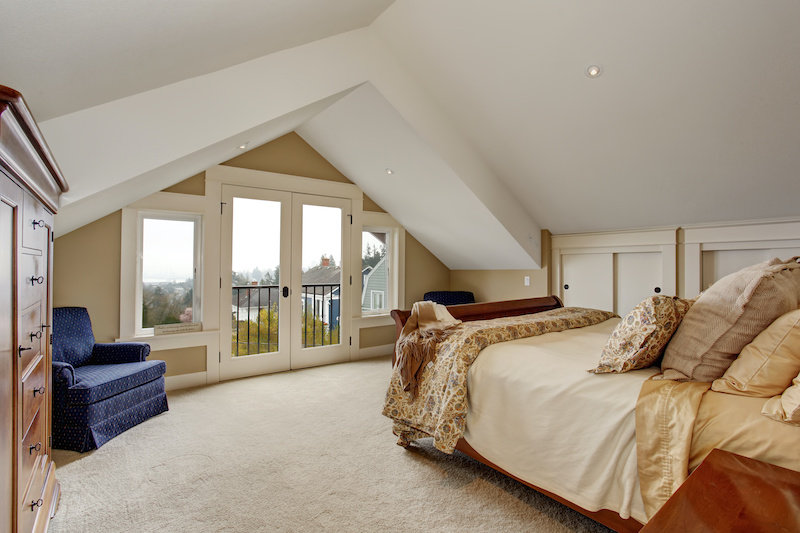 refined master bedroom with carpet, nice bedding, and balcony